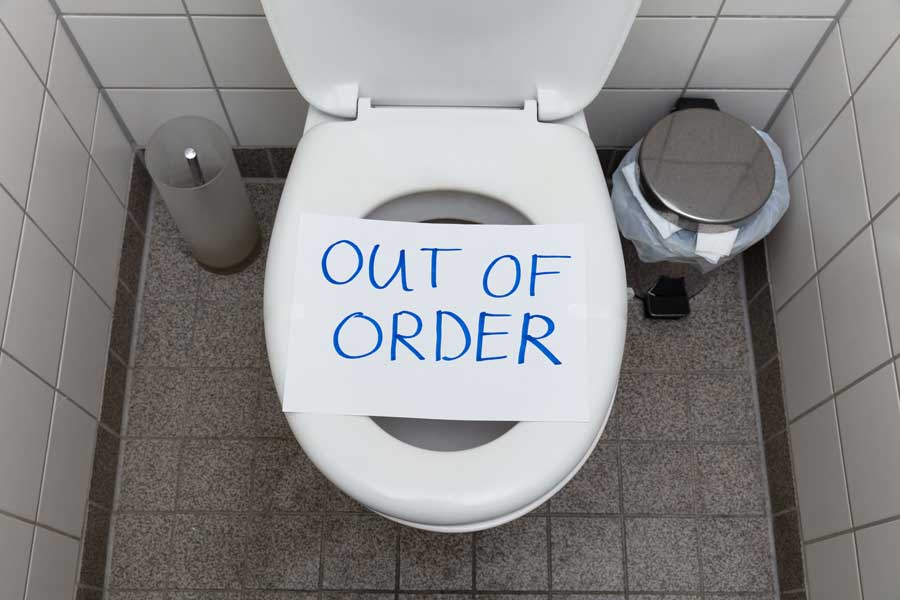 A toilet with an out of order sign